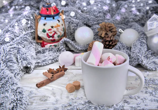 Mug full of mashmallows in milk chocolate front of christmas decor with a warm blanket — Stock Photo, Image