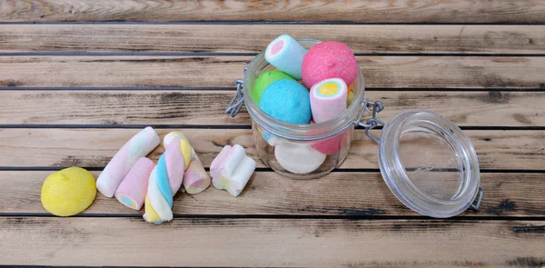 Colorful marshmallow in a glass jar on a rustic  wooden table — Stock Photo, Image