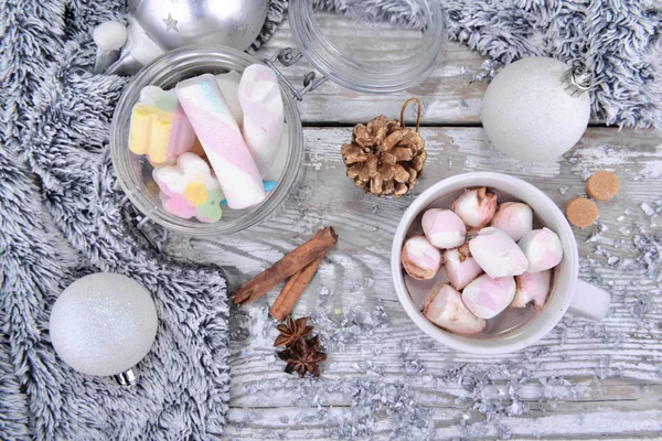 Vue de dessus sur une tasse de chocolat chaud pleine de guimauves et autres bocaux sur la décoration de Noël et une couverture chaude — Photo