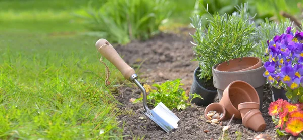 Lopată plantată în solul unei grădini lângă ghivece de flori — Fotografie, imagine de stoc