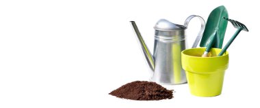 watering can, flowerpot and gardening tools behind heap of dirt on white background