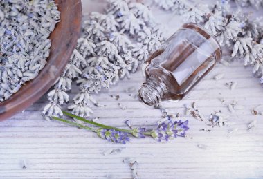 Yağ şişesine yakın ve masaya dökülen kuru lavanta. 