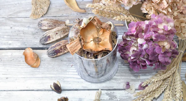 Strauß trockener Blumen und Potpourri in einem Glas auf einem weißen Tisch — Stockfoto