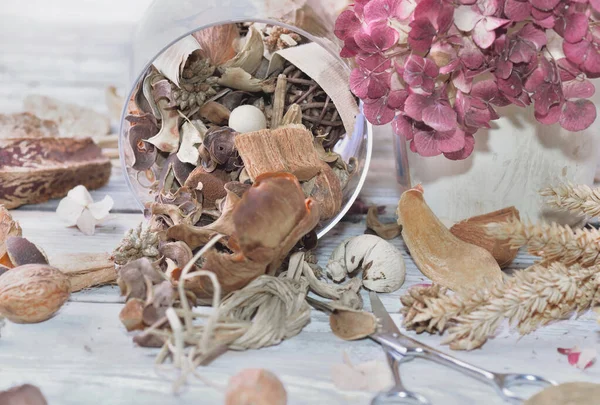 Potpourri verschüttet auf einem Tisch mit trockenen Blumen und Schere — Stockfoto