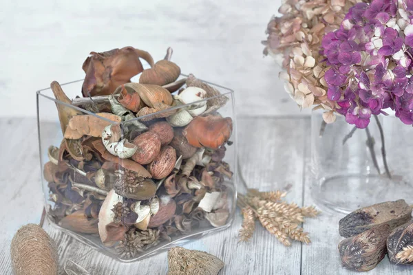 Potpourri in un vaso di vetro e fiori secchi su un tavolo — Foto Stock