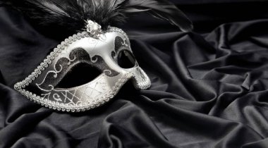 Koyu saten kumaş arka planında tüy olan karnaval mak