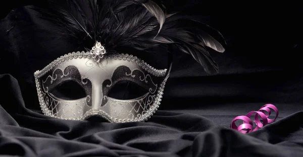 Beautiful venitian carnival mask on dark fabric background with candle and ribbon — 스톡 사진