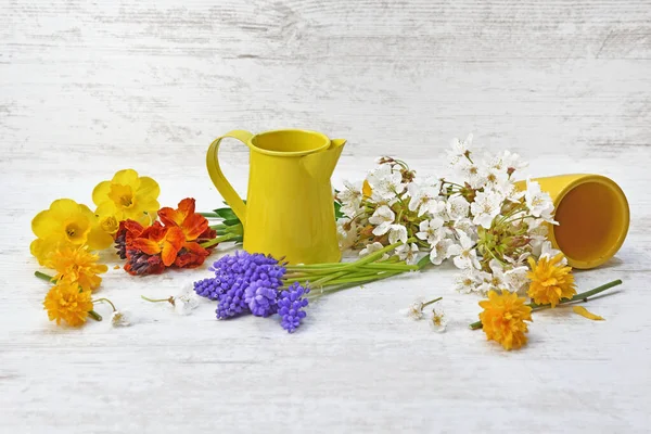 庭から摘んだ花を黄色の缶でテーブルに並べ — ストック写真