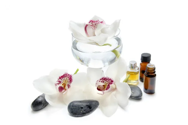 Mooie Witte Orchideeën Glazen Pot Met Olieflessen Steentjes Witte Ondergrond Stockfoto