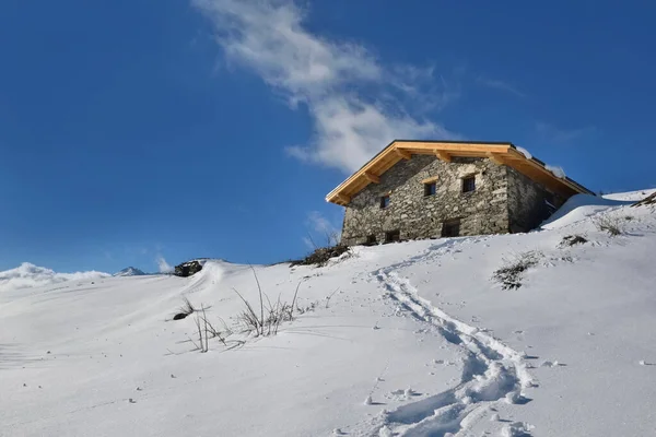 蓝天下雪山顶上的传统高山小屋 — 图库照片