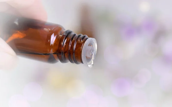 close on a essential oil bottle pouring of oil on blury background