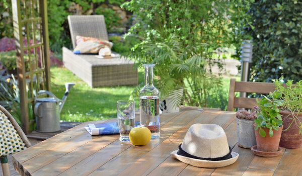 close on drink and apple on a wooden table in garden  background in summer 