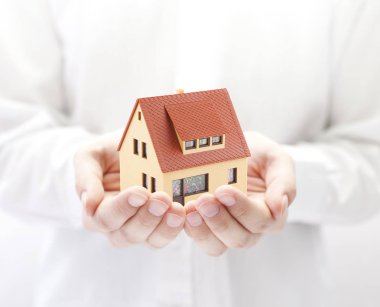 Ellerinde küçük oyuncak ev 