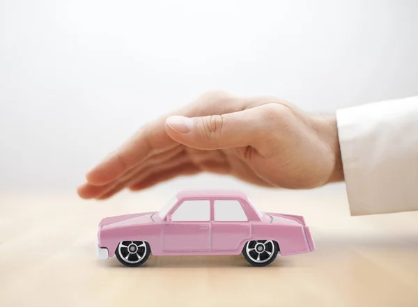 用手覆盖的经典老粉红色的车玩具 — 图库照片