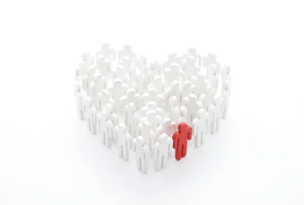 Группа людей в форме сердца с одним красным человеком — стоковое фото