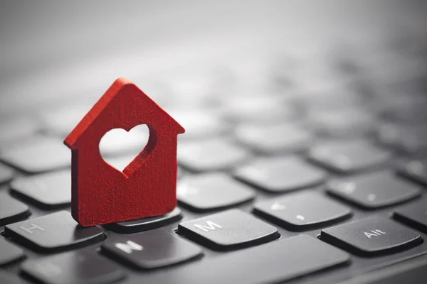 Маленький червоний будинок з серцем над клавіатурою ноутбука — стокове фото