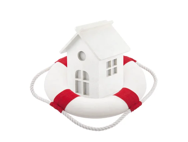 Pequena casa de brinquedo branco em lifebuoy sobre fundo branco — Fotografia de Stock