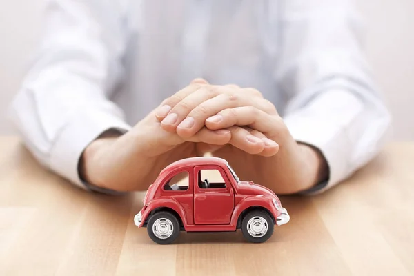 Concepto Seguro Coche Coche Juguete Rojo Cubierto Por Manos — Foto de Stock