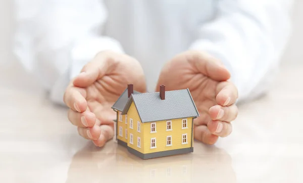 Home Insurance Concept Small Yellow House Covered Hands — Stock Photo, Image