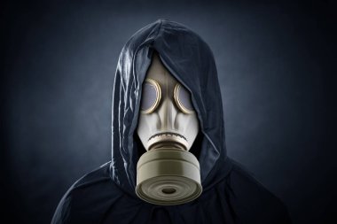 Man in a gas mask and hooded cloak. Environment pollution. clipart