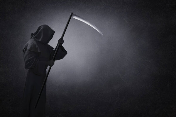 Grim reaper with scythe in the dark