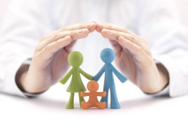 Family insurance concept with colorful family figurines covered by hands