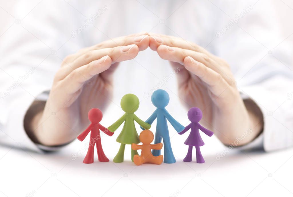 Family insurance concept with colorful family figurines covered by hands
