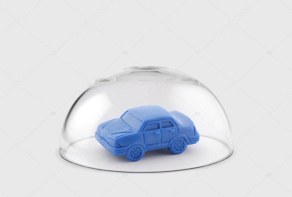 Blue toy car protected under a glass dome