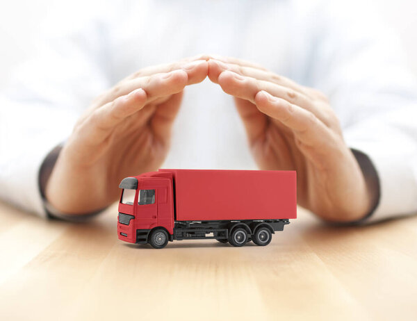 Red cargo delivery truck protected by hands