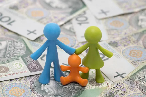 Colorful family figurines on polish money. Financial help for families in Poland or family expenses concept