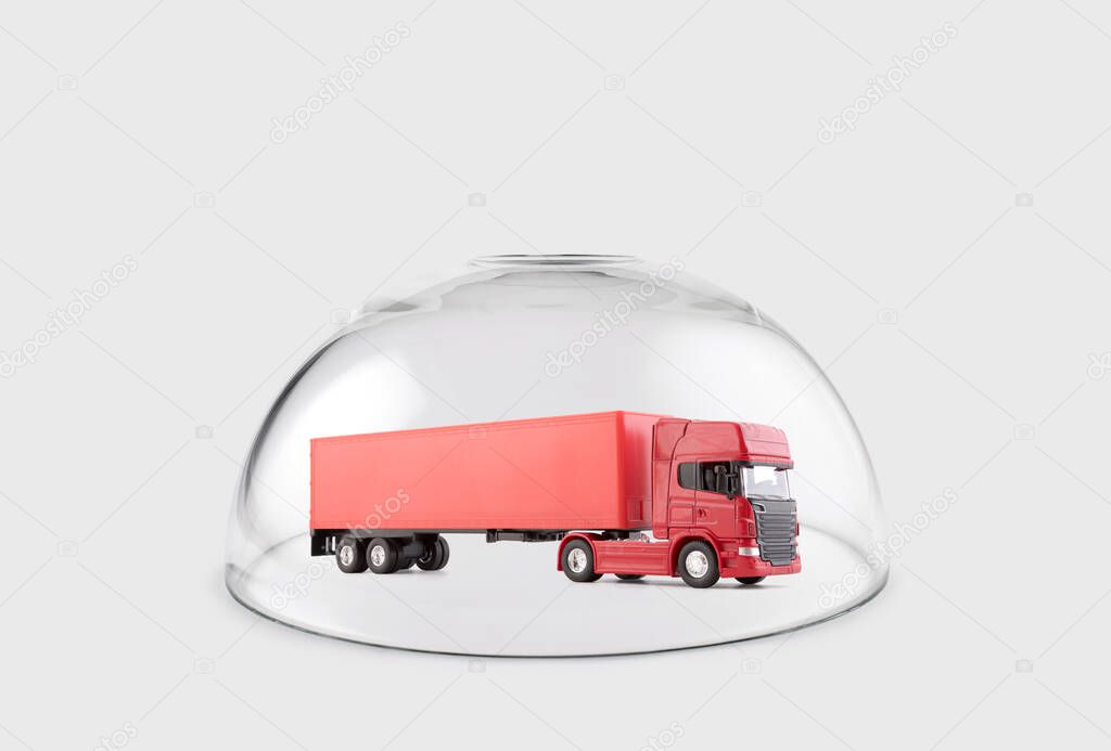 Red long truck with a trailer protected under a glass dome