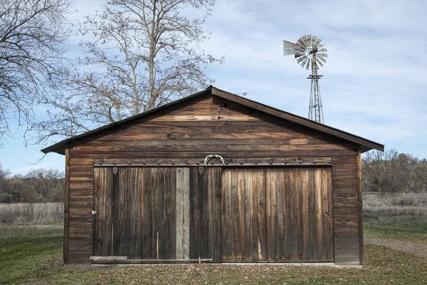 Edifício velho da fazenda com moinho de vento — Fotografia de Stock