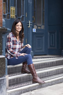 Onu kapının önünde oturan genç kadın