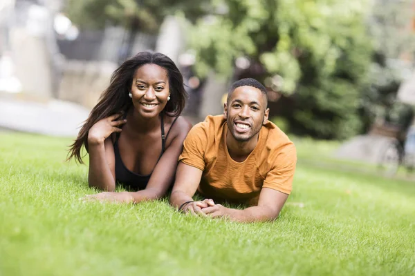 公園の草の上に横たわる若いカップル — ストック写真