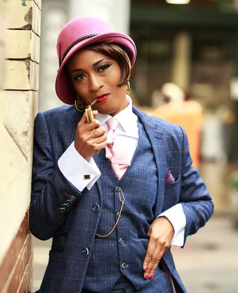 a young woman smoking dressed in a tweed suit