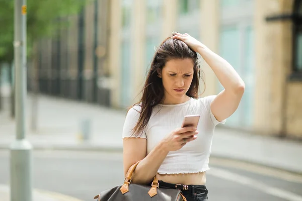 路上でテキストメッセージを読んでいる若い女性は — ストック写真