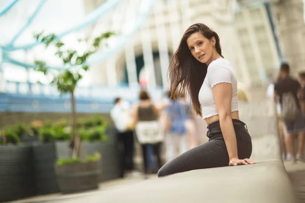 Eine Junge Frau Sitzt Auf Einer Mauer — Stockfoto