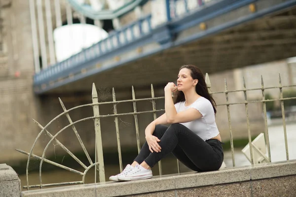 Junge Frau Sitzt Auf Einer Mauer Der Turmbrücke — Stockfoto