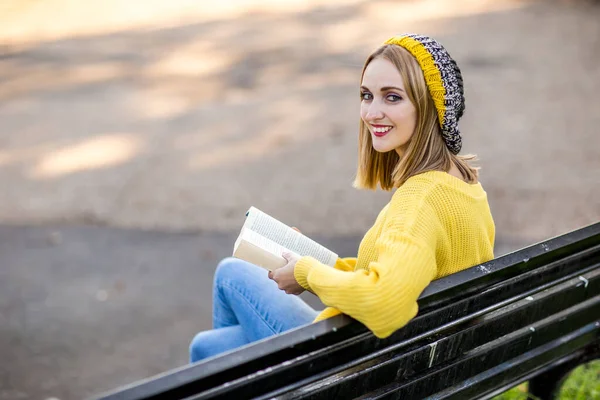 Jovem Mulher Com Livro Olhando Para Trás Sobre Seu Ombro — Fotografia de Stock