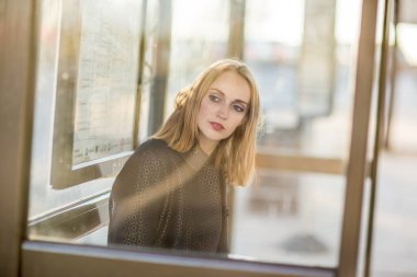 Genç bayan otobüs durağında bekliyor.