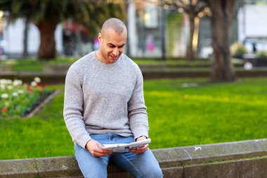 Gazete okuyan genç bir adam.