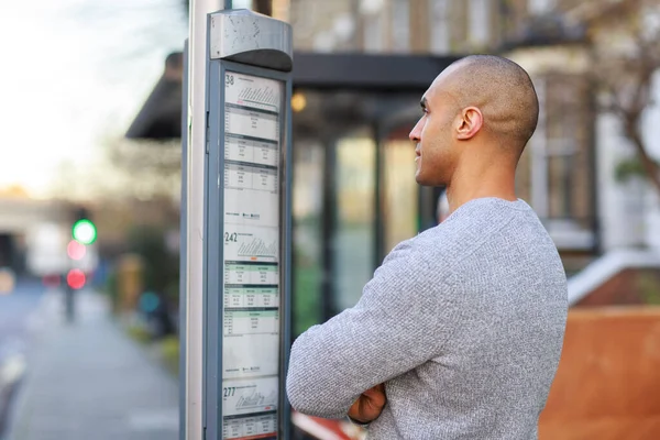 Young Man Reading Bus Timetable — Stock Photo, Image