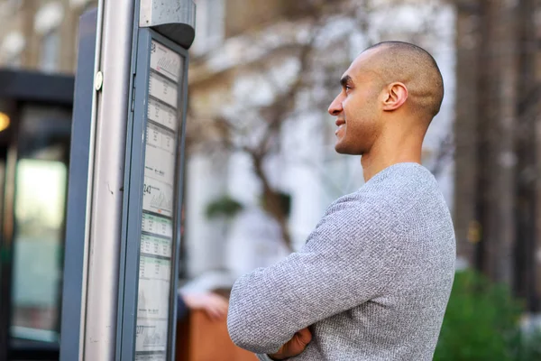 Młody Człowiek Czytający Rozkład Jazdy Autobusów — Zdjęcie stockowe