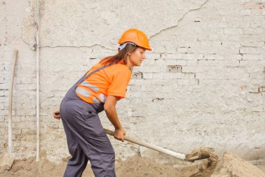 Mutlu kadın boşaltma kum inşaat ve bir telefonda konuşurken