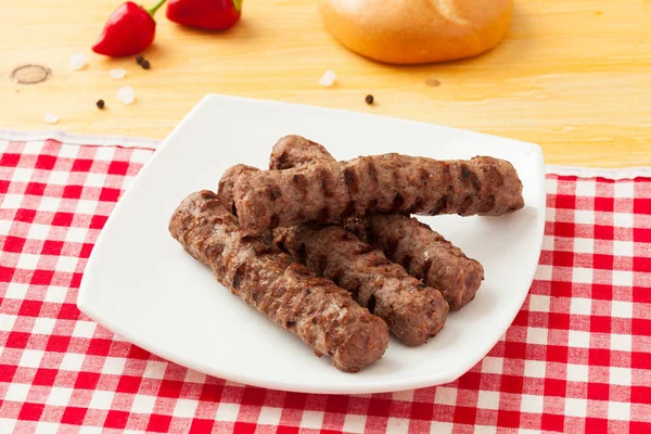 Kebapche de ternera a la parrilla con verduras y pan en un plato blanco —  Fotos de Stock