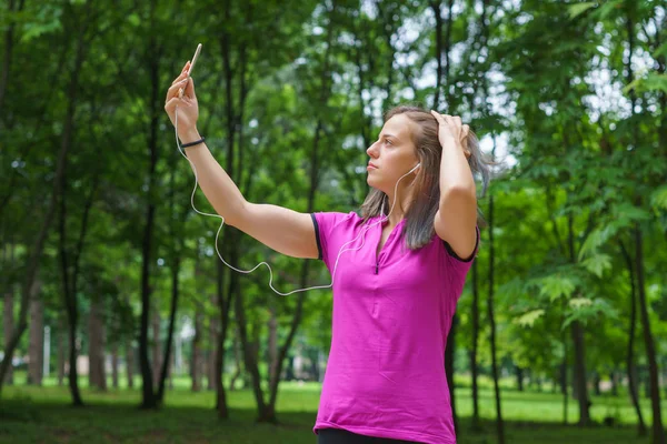 Unga fitness kvinna tar Selfie utomhus under övningar — Stockfoto
