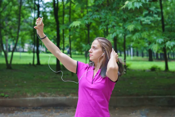 Jovem mulher fitness tomando Selfie ao ar livre durante os exercícios — Fotografia de Stock