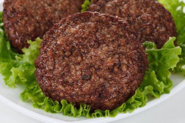 Kızarmış köfte ve marul yaprakları beyaz tabak içinde