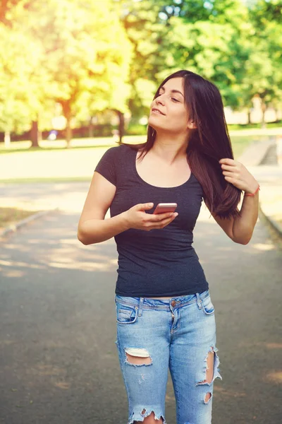 Young woman texting on smart phone outdoors — Stock Photo, Image