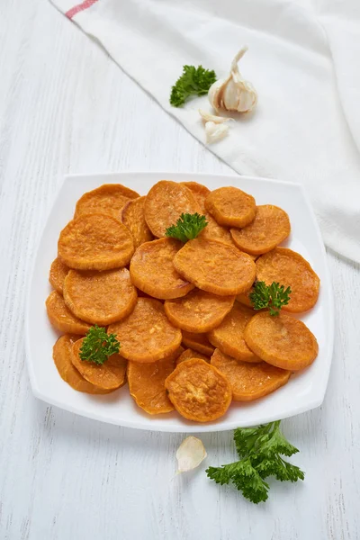 Batatas al horno en plato blanco sobre una mesa de madera blanca —  Fotos de Stock